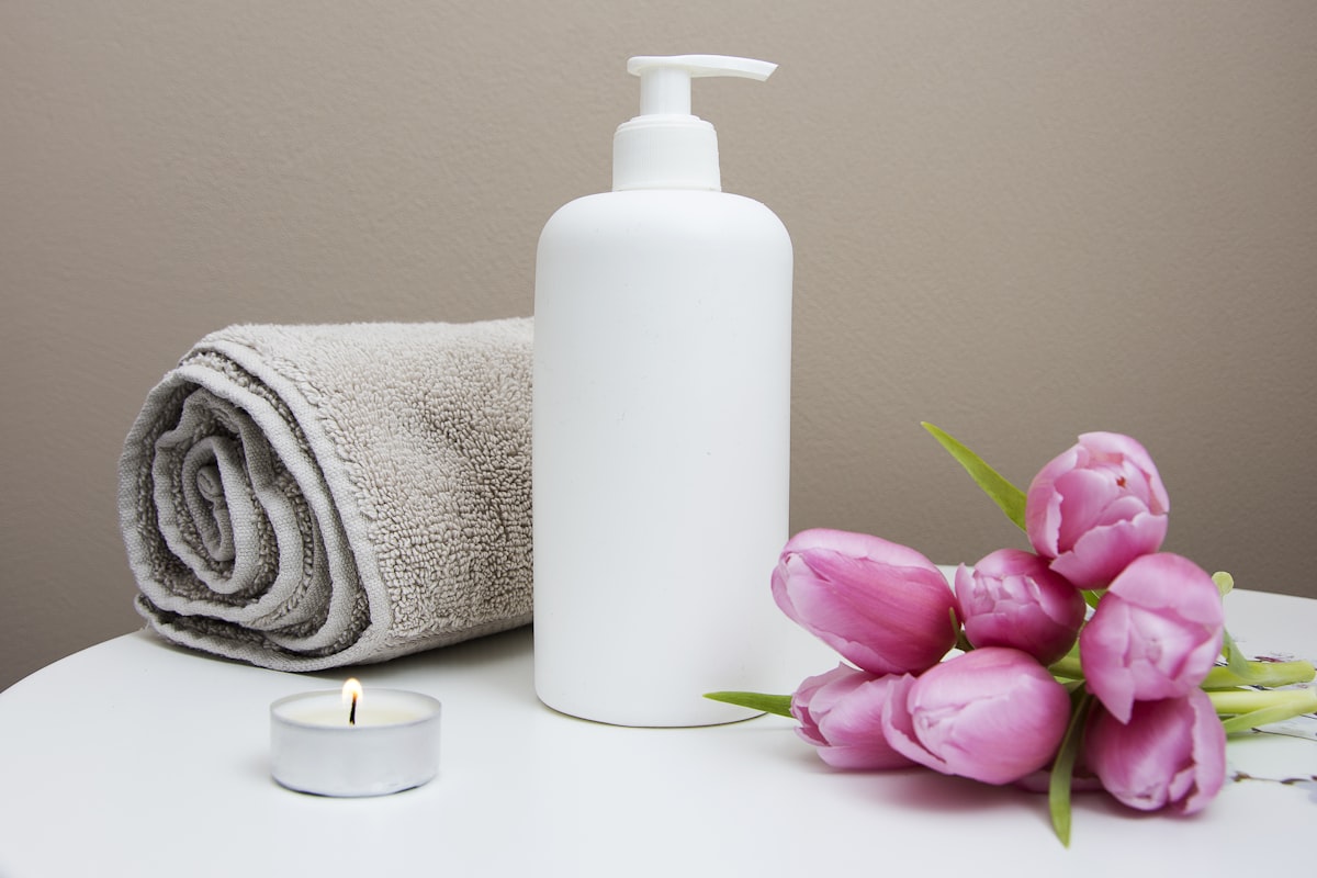 Rolled spa towel, candles, and an aromatherapy diffuser